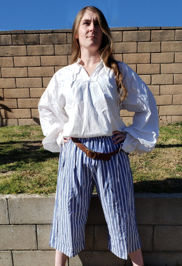 the She Devil of the Sea poses wearing blue and white striped pirate breeches